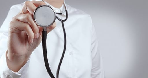 A person holds the end of a stethoscope